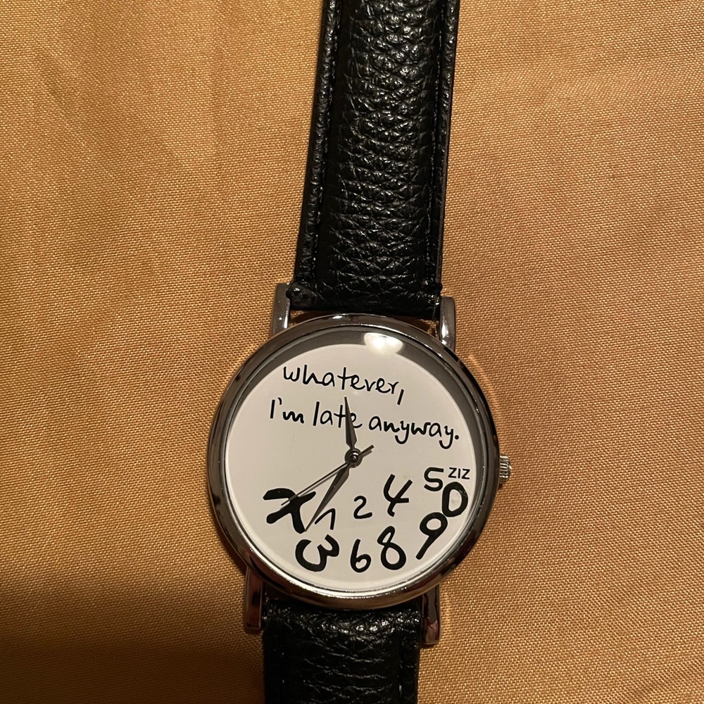 Black watch with the saying “Whatever I’m late anyway” and the numbers scrambled